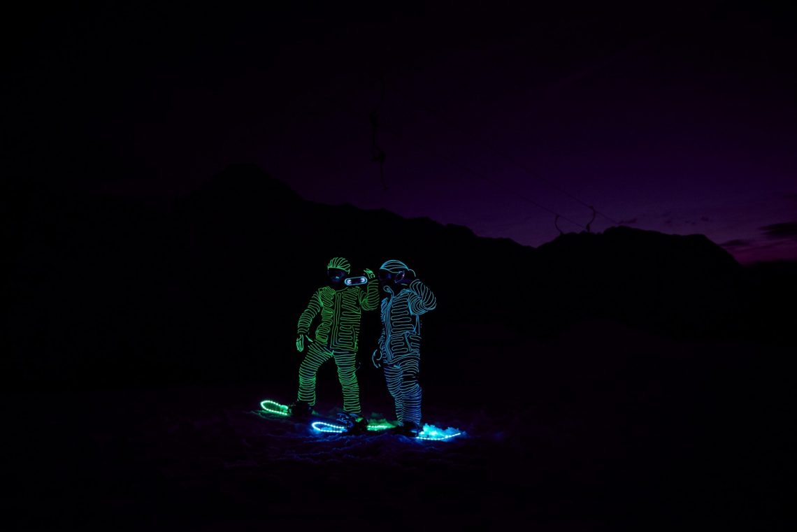 Snowboarders in LED suits