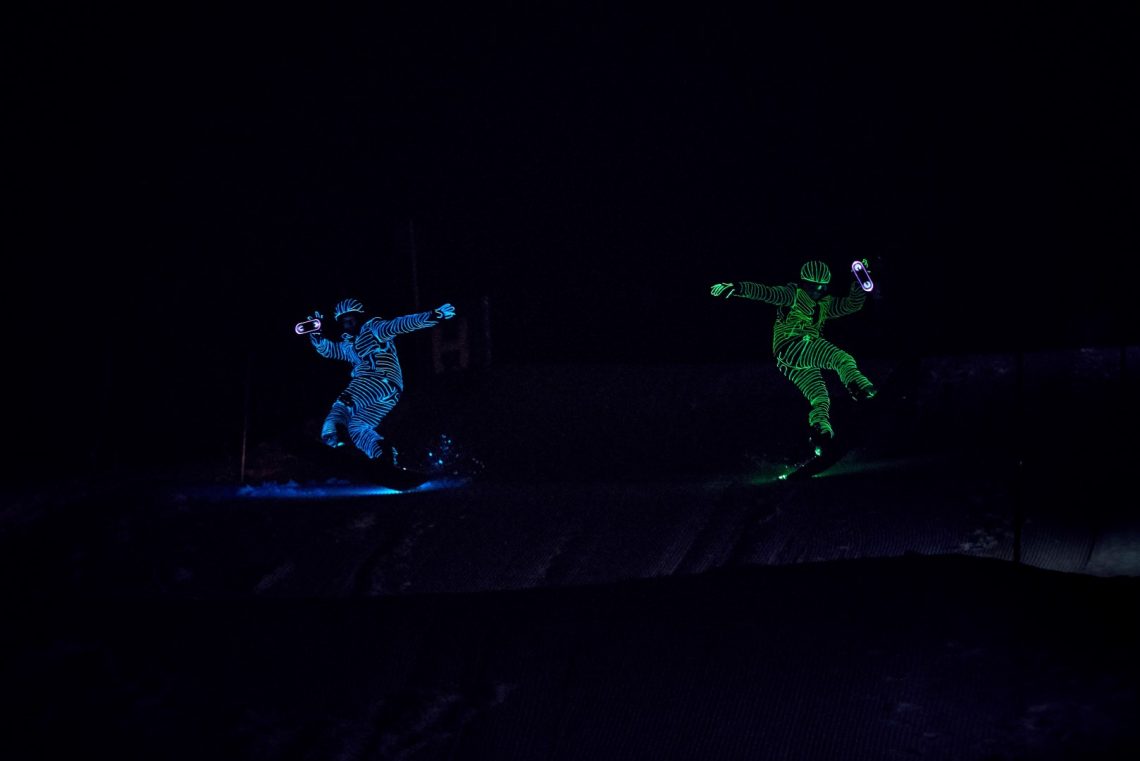 Snowboarders in LED suits