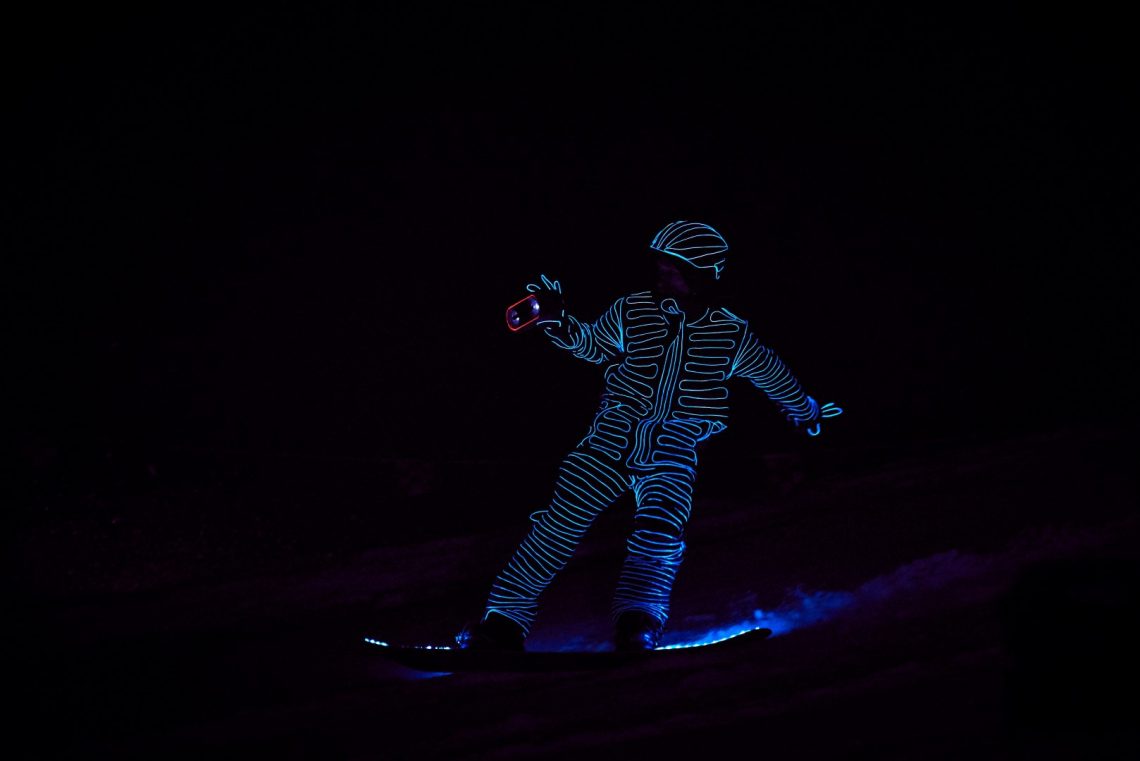Snowboarders in LED suits
